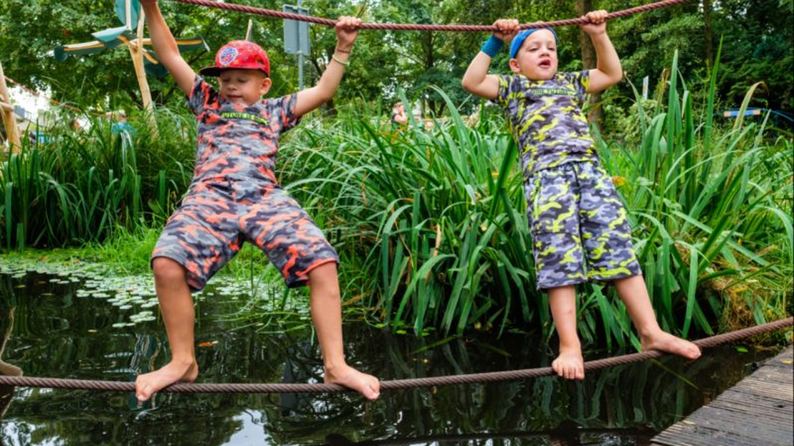 Twee kinderen op een speeltoestel. Lees meer over hoe je zelf speeltoestellen bouwt voor de speeltuin - Jantje Beton