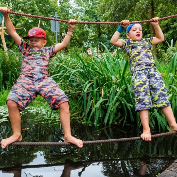 Twee kinderen op een speeltoestel. Lees meer over hoe je zelf speeltoestellen bouwt voor de speeltuin - Jantje Beton