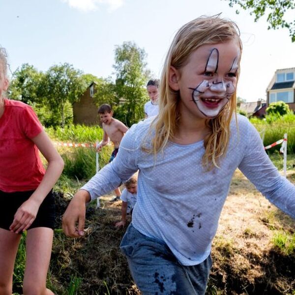 Kinderen spelen in de speeltuin waar het werven van vrijwilligers essentieel is voor de toekomst - Jantje Beton