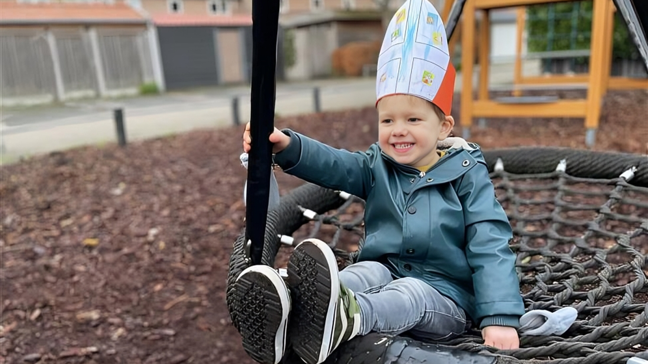 jongen met Sinterklaas mijter op schommel