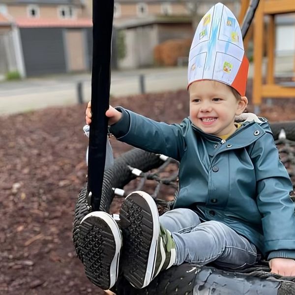 jongen met Sinterklaas mijter op schommel