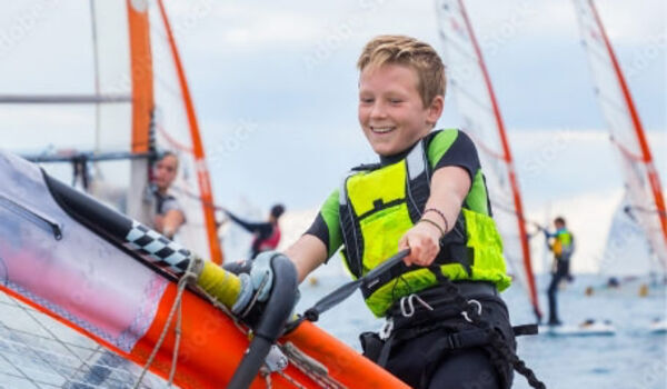 Jongen op een boot tijdens een kindervakantieorganisatie. Ontdek de voordelen van aangesloten te zijn bij Jantje Beton als speeltuin of kindervakantieorganisatie.