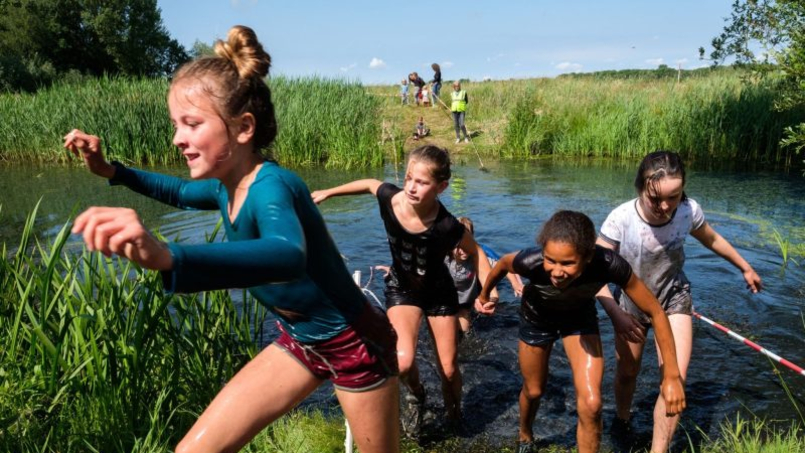 Kinderen rennen door het water tijdens een kinderkamp. Deze en andere programmatips voor op kamp lees je hier - Jantje Beton