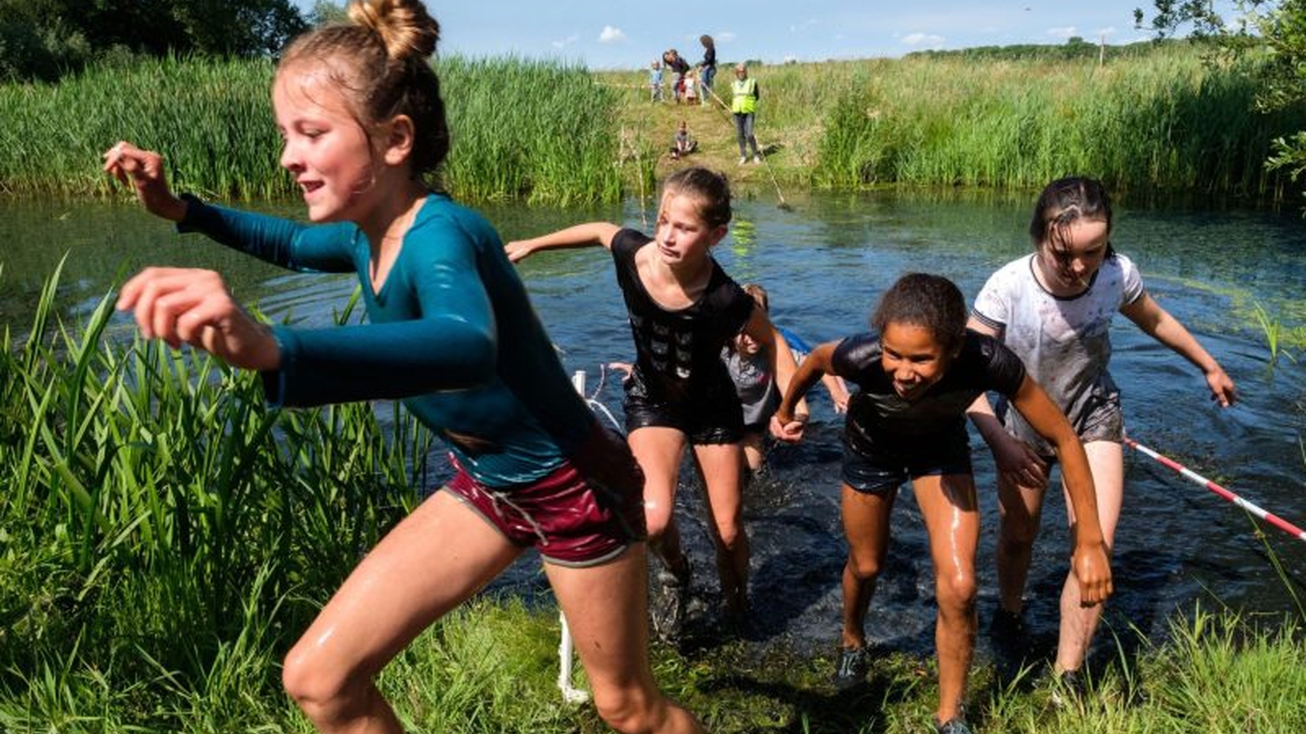 Kinderen rennen door het water tijdens een kinderkamp. Deze en andere programmatips voor op kamp lees je hier - Jantje Beton