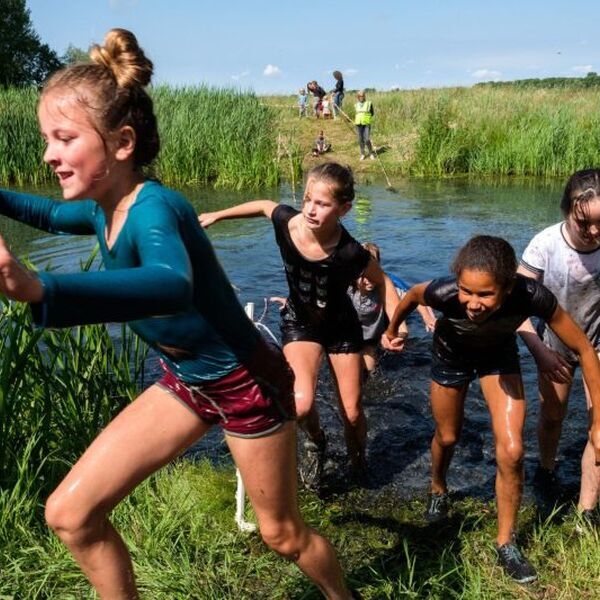 Kinderen rennen door het water tijdens een kinderkamp. Deze en andere programmatips voor op kamp lees je hier - Jantje Beton