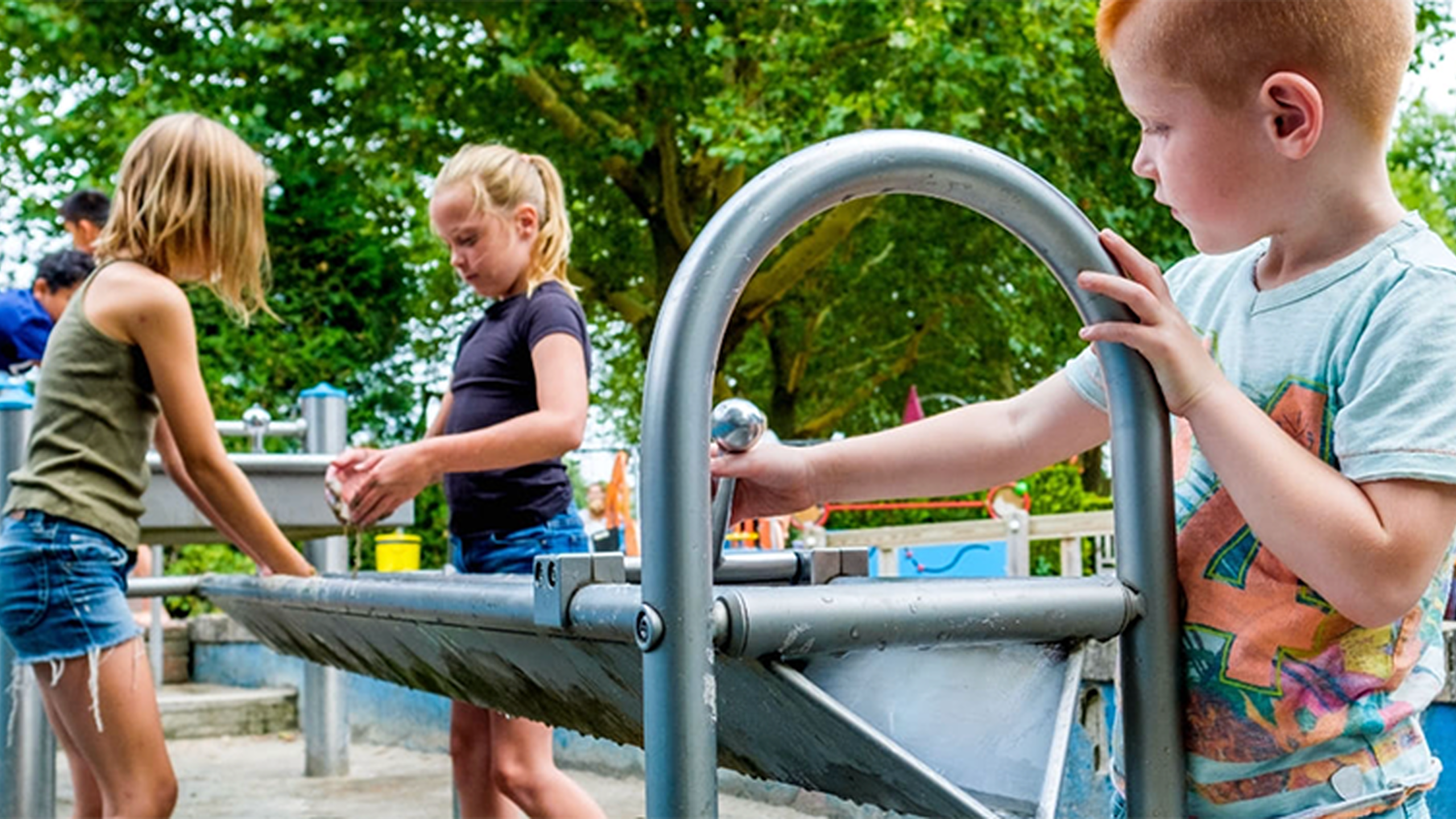 Kinderen spelen bij een waterbak. Sluit je nu ook aan als Speelpartner van Jantje Beton voor diverse voordelen.