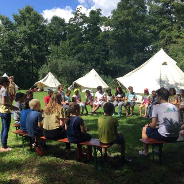 Vrijwilligers van een speeltuin zitten in een kring. Vrijwilligers zijn belangrijk. Lees hoe je ze werft en behoudt voor jouw speeltuin - Jantje Beton