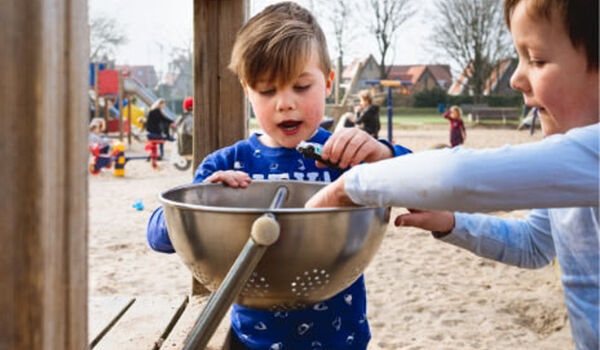 Twee kinderen spelen in een zandbak. Als aangesloten organisatie bij Jantje Beton geniet je diverse voordelen - Jantje Beton