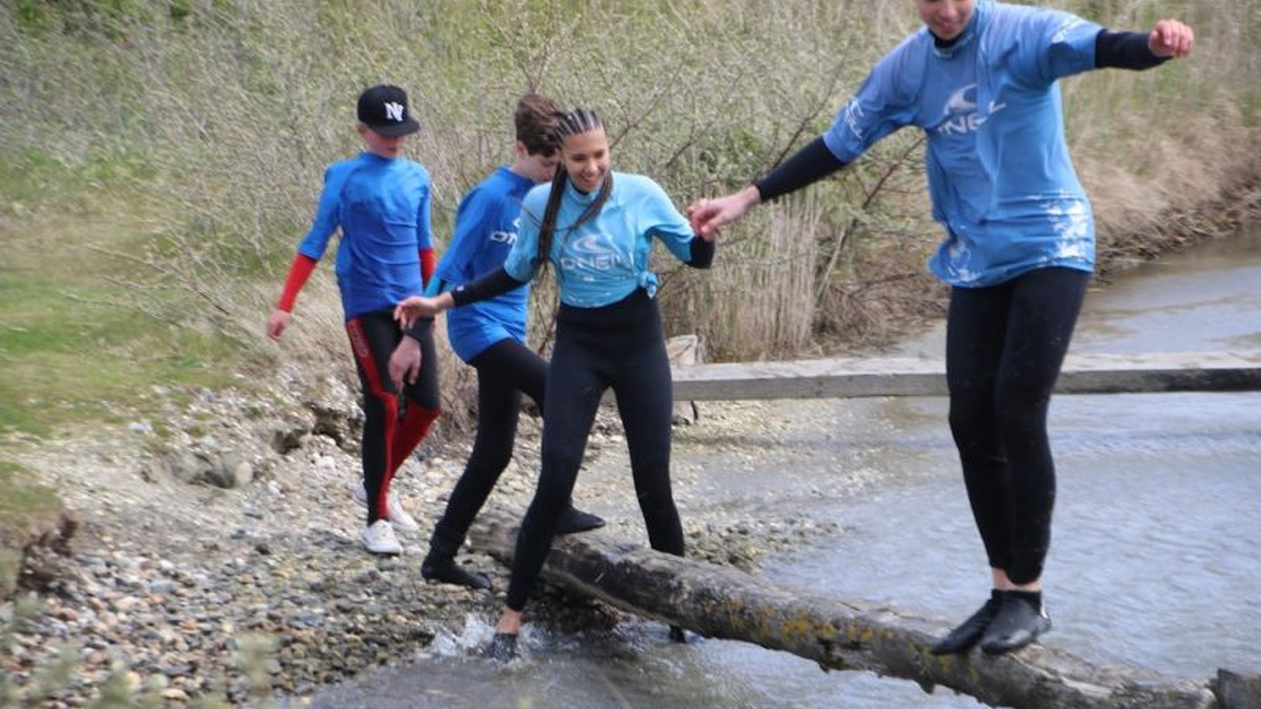 Kinderen steken een rivier over via een boomstam. Lees op deze pagina meer over het WBTR stappenplan - Jantje Beton