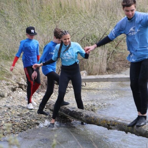 Kinderen steken een rivier over via een boomstam. Lees op deze pagina meer over het WBTR stappenplan - Jantje Beton