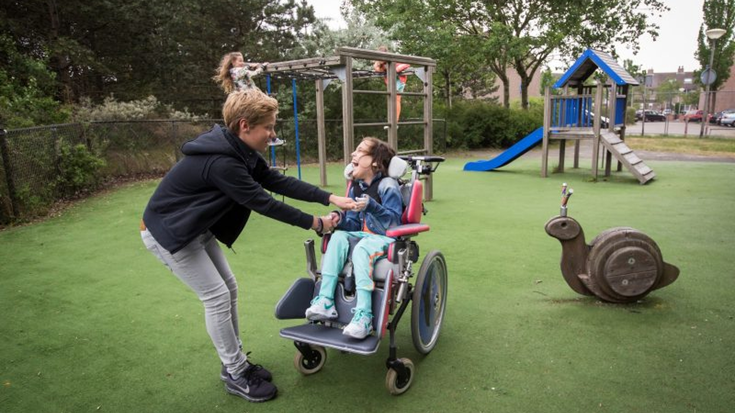 Kind in een rolstoel speelt in de speeltuin. Een foto bij de column van Rick Brink - Jantje Beton