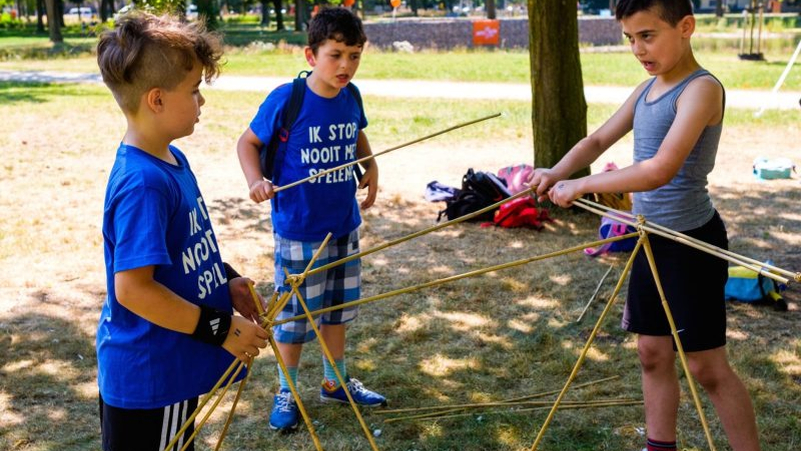 Kinderen doen een spel in een speeltuin. Pestgedrag signaleren is belangrijk in een speeltuin. Lees wat je als speeltuin of vrijwilliger kan doen - Jantje Beton