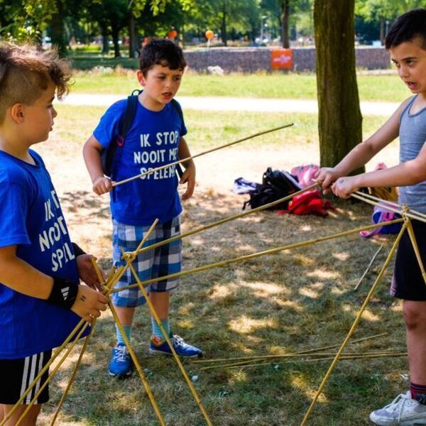 Kinderen doen een spel in een speeltuin. Pestgedrag signaleren is belangrijk in een speeltuin. Lees wat je als speeltuin of vrijwilliger kan doen - Jantje Beton